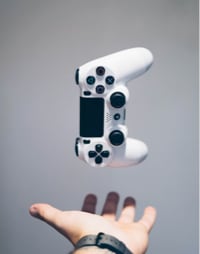 a playstation 4 controler that is launched in the air above a hand